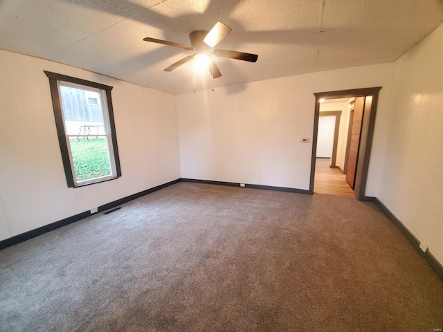 unfurnished room featuring ceiling fan, light carpet, and a textured ceiling