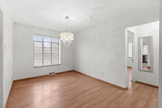 unfurnished dining area featuring light wood-type flooring and a notable chandelier