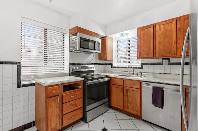 kitchen featuring sink, light tile patterned floors, and stainless steel appliances