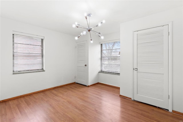 unfurnished bedroom featuring a chandelier and hardwood / wood-style flooring