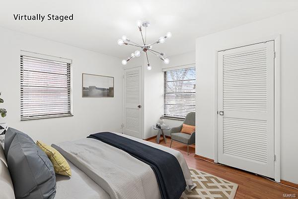 bedroom with hardwood / wood-style flooring and a notable chandelier