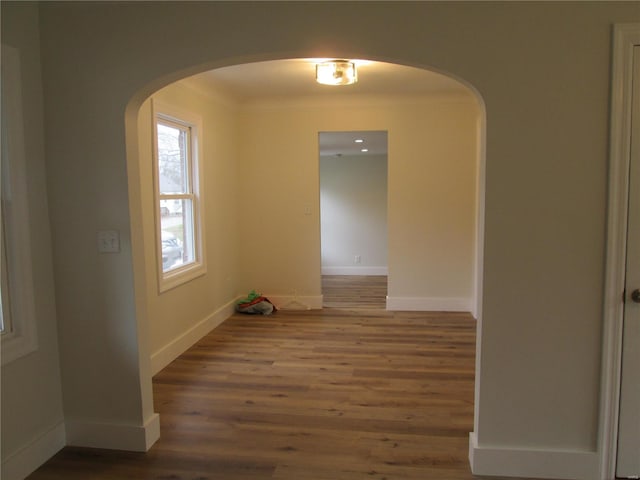 spare room with hardwood / wood-style flooring and crown molding