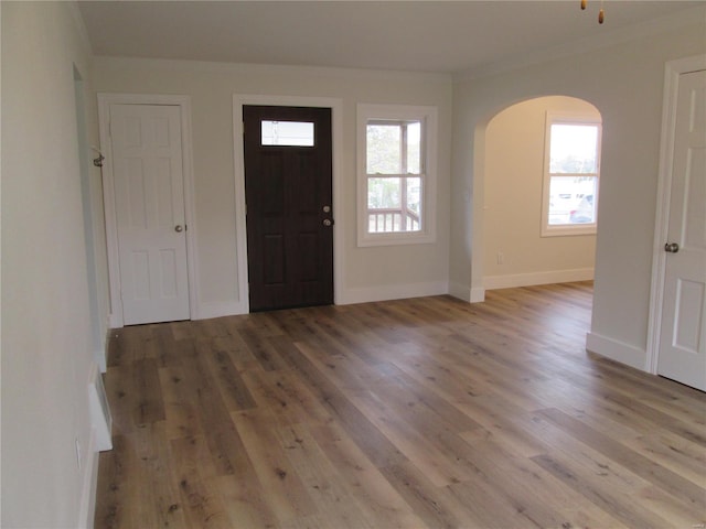 entrance foyer with ornamental molding and light hardwood / wood-style flooring