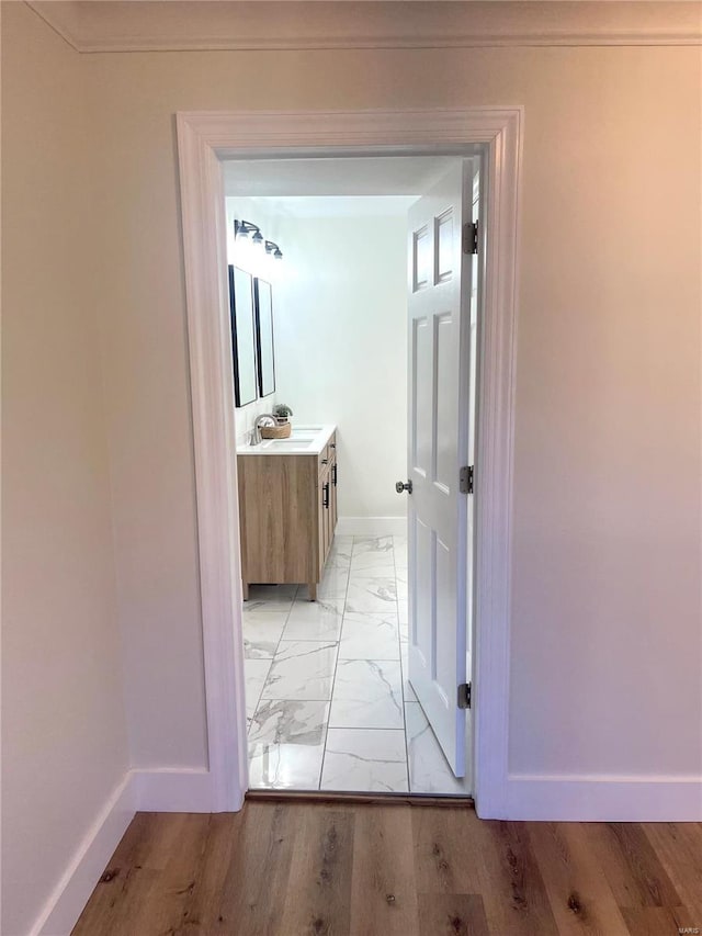 hallway featuring sink and light hardwood / wood-style flooring