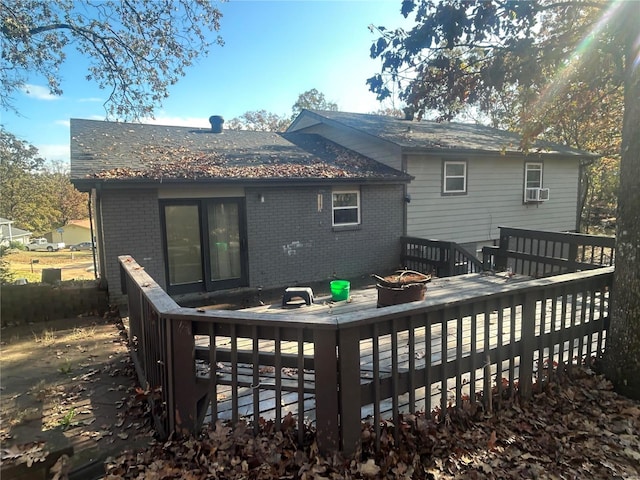 rear view of property featuring a wooden deck and a fire pit