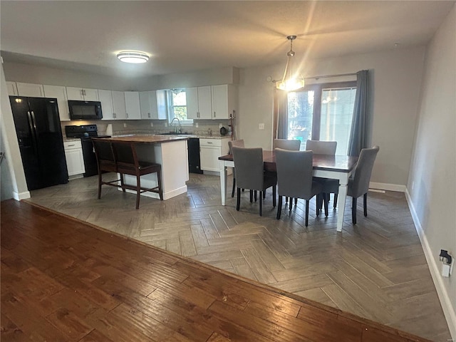 dining space with dark parquet flooring, plenty of natural light, and sink