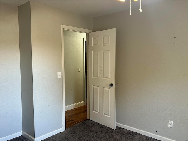 unfurnished bedroom with dark carpet