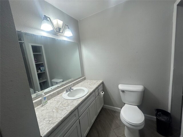 bathroom featuring hardwood / wood-style floors, vanity, and toilet