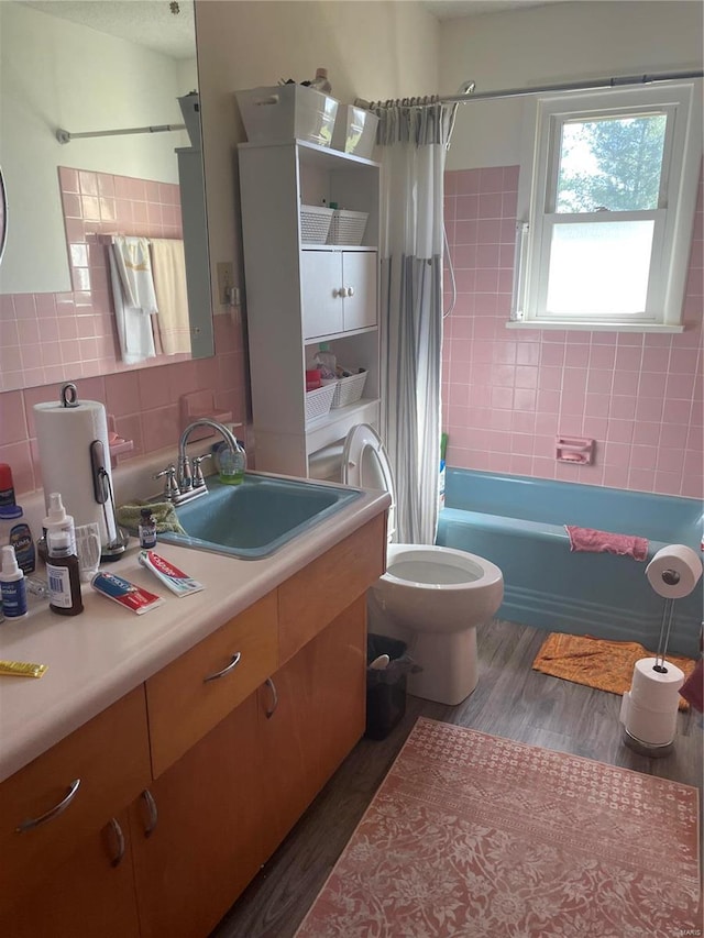 full bathroom featuring shower / bathtub combination with curtain, wood-type flooring, vanity, toilet, and tile walls