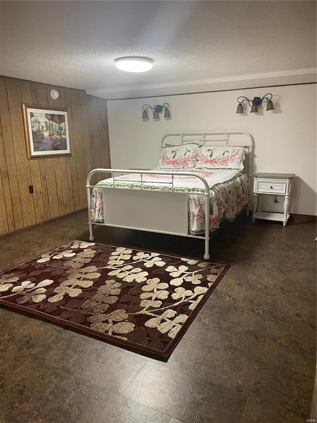 bedroom with a textured ceiling and wooden walls