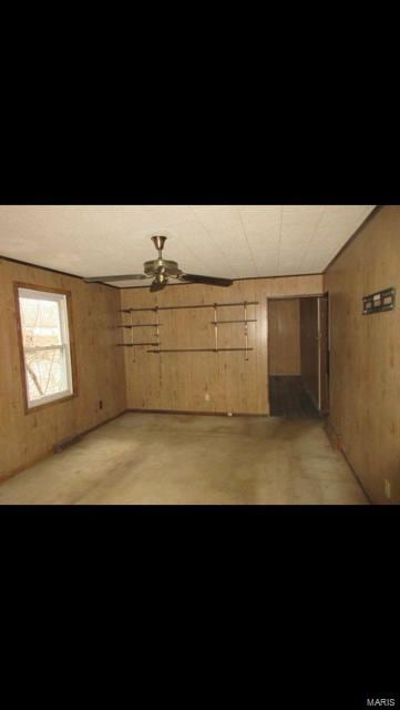 unfurnished room featuring wood walls