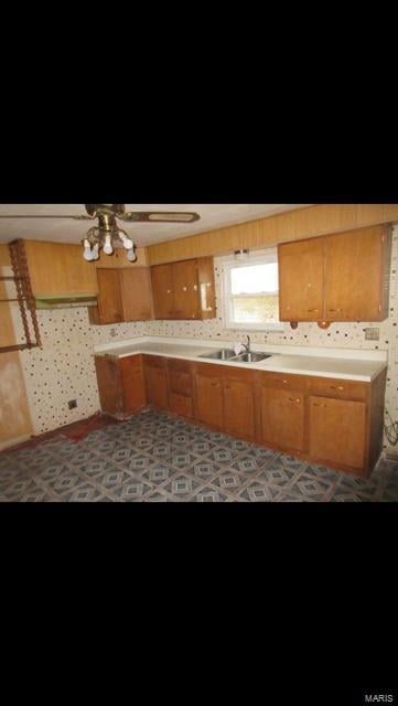 kitchen featuring ceiling fan and sink