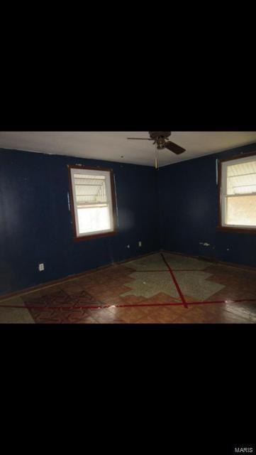 unfurnished room with ceiling fan and a healthy amount of sunlight