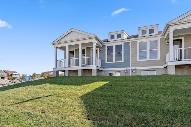 rear view of property featuring a porch and a lawn