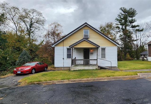 bungalow with a front lawn and covered porch