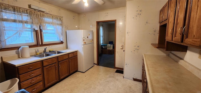 kitchen with ceiling fan, white fridge, and sink