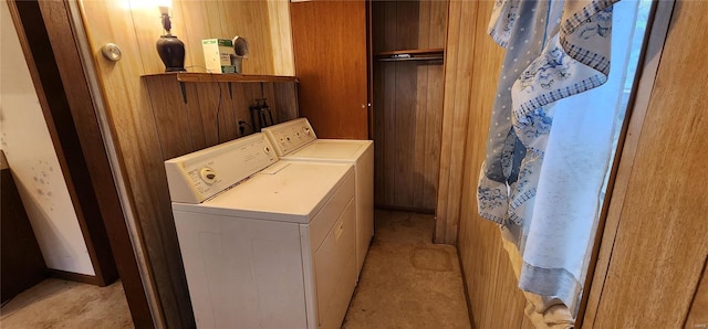 laundry room featuring wooden walls and washing machine and clothes dryer