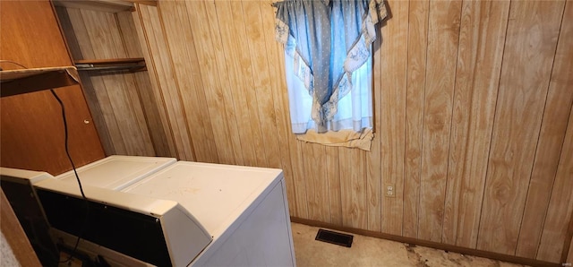 laundry room featuring washer and clothes dryer and wooden walls