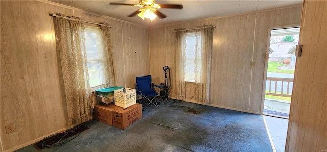 interior space featuring wood walls and ceiling fan