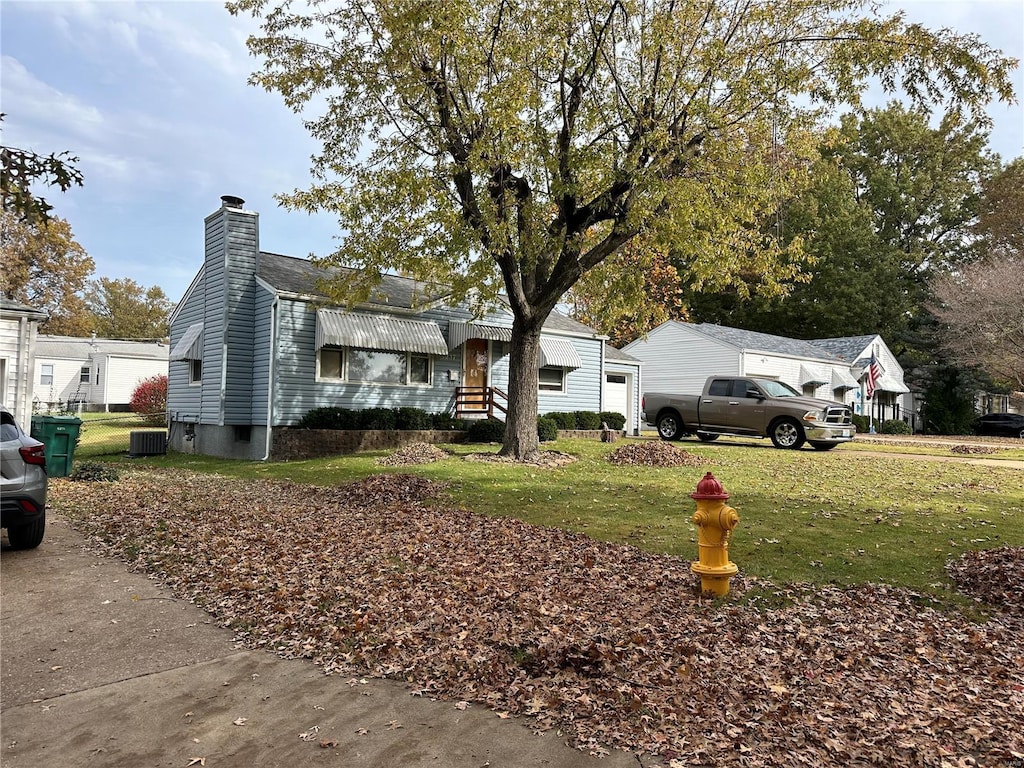 view of front of home featuring cooling unit and a front lawn