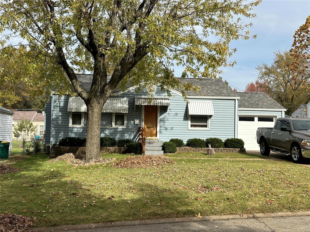 view of front of home with a front yard and a garage