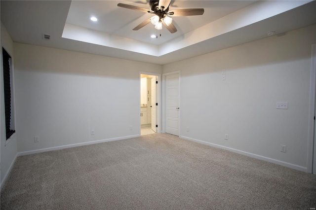 unfurnished room featuring ceiling fan, carpet, and a tray ceiling