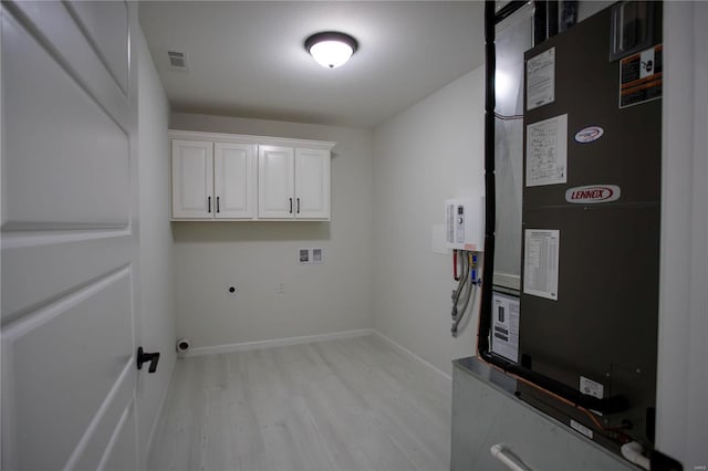 clothes washing area with heating unit, hookup for a washing machine, cabinets, light hardwood / wood-style floors, and electric dryer hookup