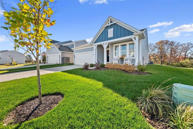 view of front facade with a front yard, central AC, covered porch, and a garage