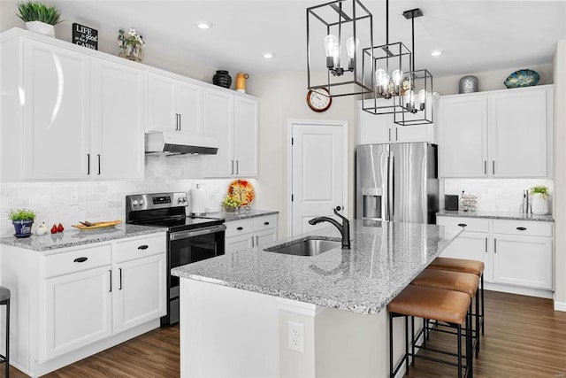 kitchen with stainless steel appliances, white cabinets, sink, an island with sink, and dark hardwood / wood-style floors