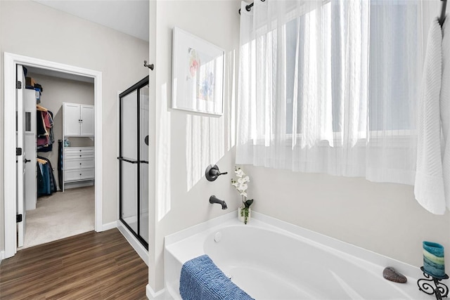 bathroom with hardwood / wood-style floors and independent shower and bath