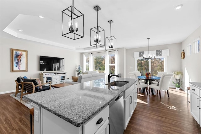 kitchen with a healthy amount of sunlight, sink, pendant lighting, and white cabinetry