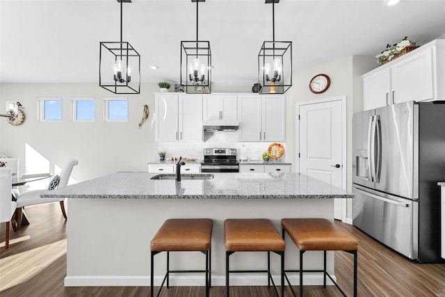 kitchen with stainless steel appliances, a center island with sink, sink, dark hardwood / wood-style floors, and white cabinetry