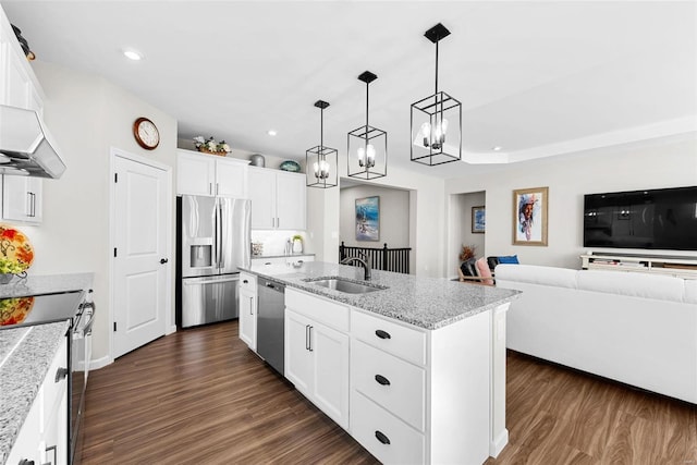 kitchen featuring stainless steel appliances, a center island with sink, sink, and white cabinets