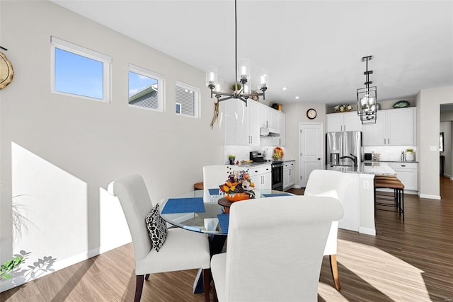 dining space featuring dark wood-type flooring and a notable chandelier