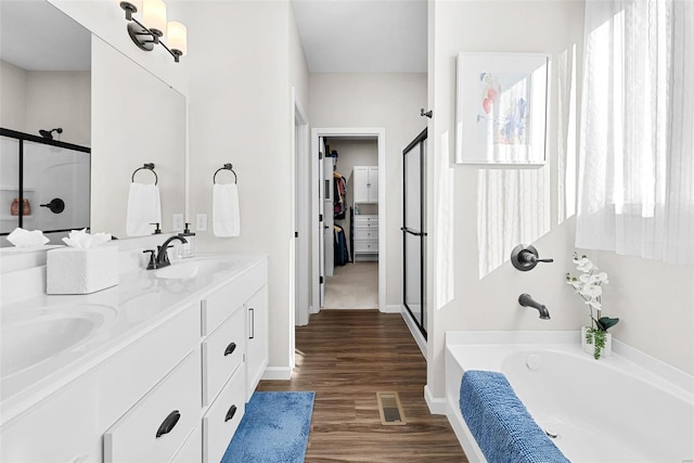 bathroom with independent shower and bath, wood-type flooring, and vanity