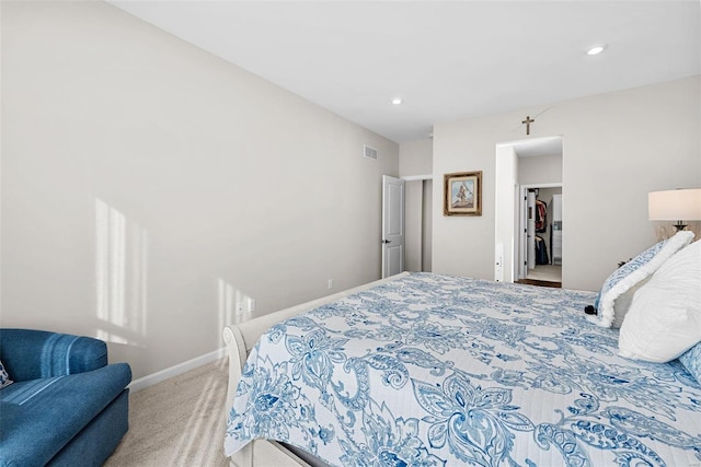 bedroom featuring light colored carpet and a spacious closet