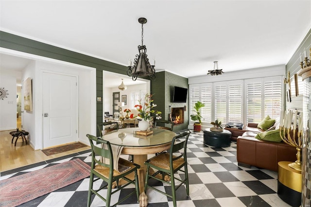 dining space featuring a large fireplace, a chandelier, and wood-type flooring