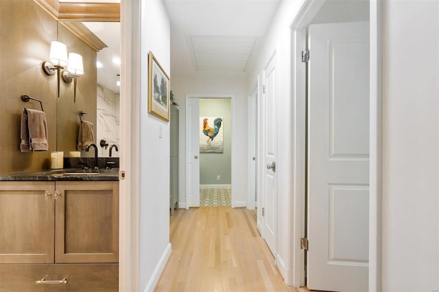 hallway with sink and light hardwood / wood-style flooring