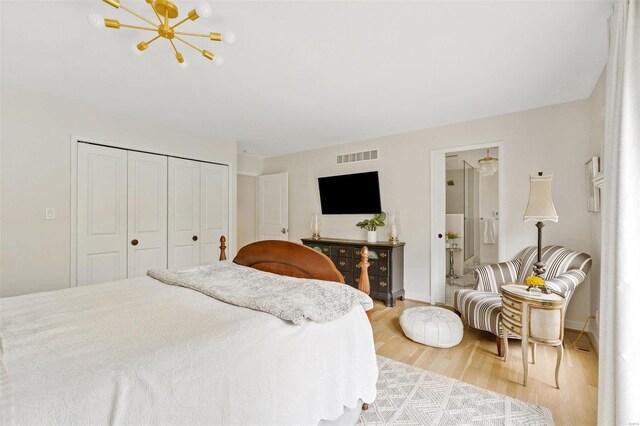 bedroom featuring hardwood / wood-style floors, ensuite bathroom, and a closet