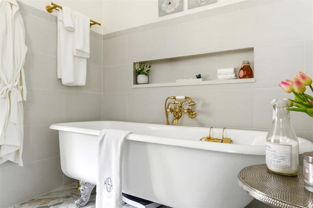 bathroom with a washtub and tile walls