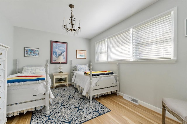 bedroom featuring light hardwood / wood-style flooring and a notable chandelier