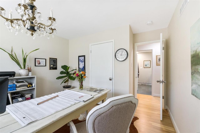 office featuring light hardwood / wood-style floors and a notable chandelier