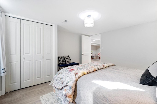 bedroom with light wood-type flooring and a closet