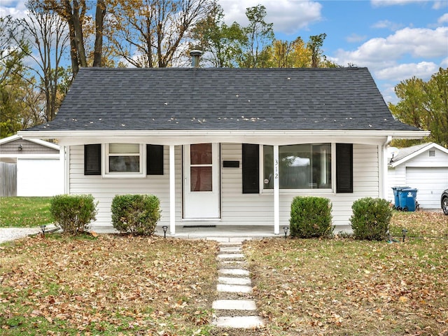 bungalow with an outbuilding, a garage, and covered porch