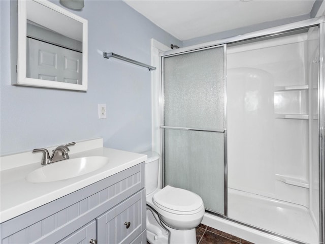 bathroom featuring toilet, vanity, an enclosed shower, and tile patterned flooring