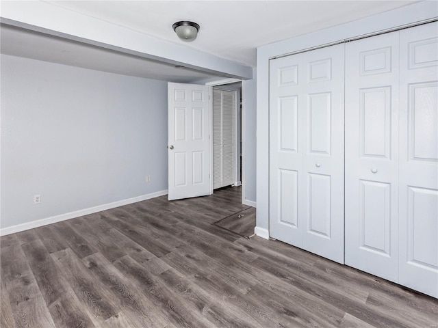 unfurnished bedroom featuring dark hardwood / wood-style flooring and a closet