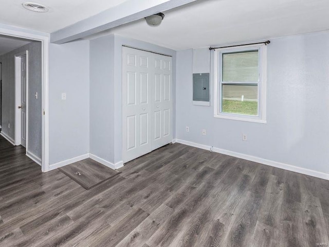 unfurnished bedroom with dark wood-type flooring, a closet, and electric panel