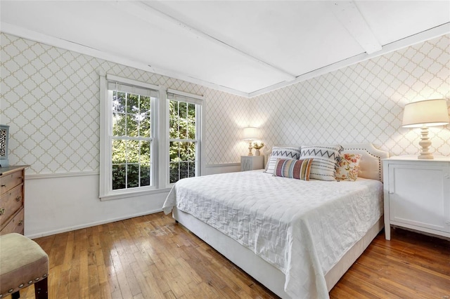 bedroom with beam ceiling and wood-type flooring