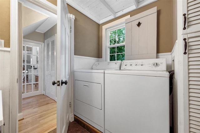 clothes washing area featuring washer and dryer, light hardwood / wood-style floors, and wood ceiling