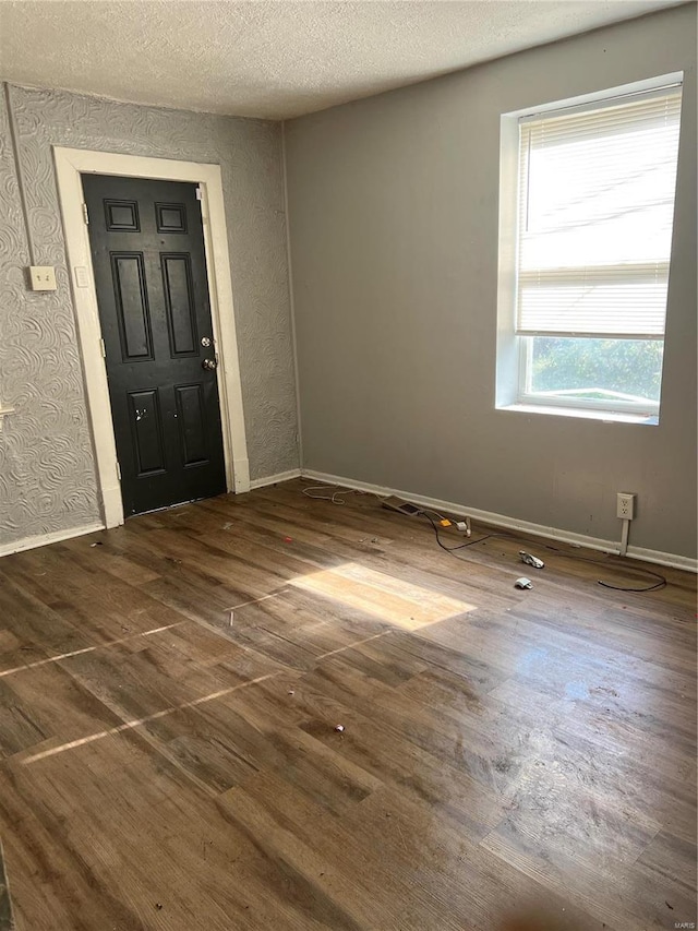 foyer featuring dark wood-type flooring and a textured ceiling